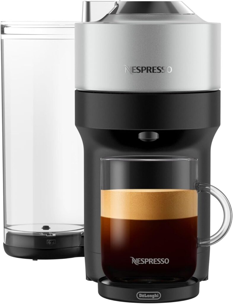 a nespresso vertuo pop coffee maker with a glass and a mug